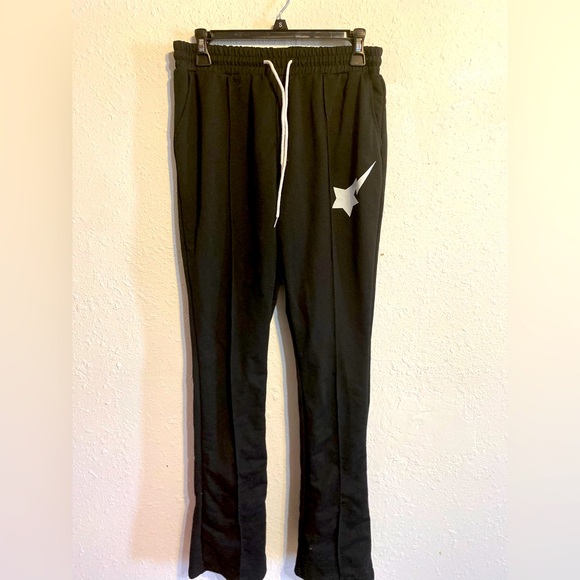 Black pants with shooting star logo on front and bottom flare legs - Picture 1 of 3